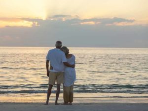 Senior man and woman couple embracing at sunset or sunrise on a deserted tropical beach. They relay in Jakob Legal for Probate