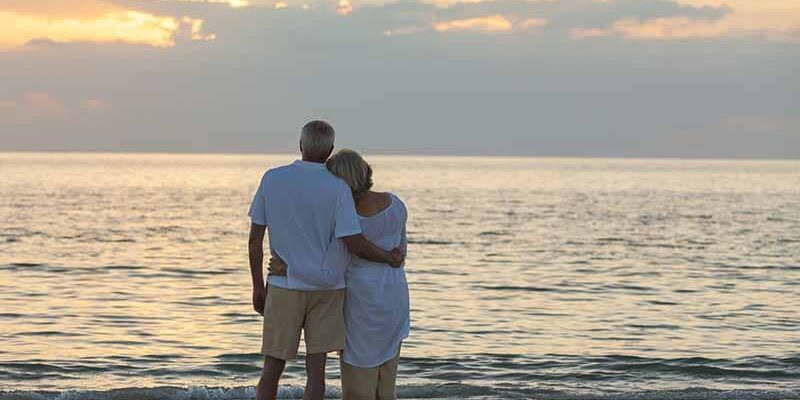 Senior man and woman couple embracing at sunset or sunrise on a deserted tropical beach. They relay in Jakob Legal for Probate